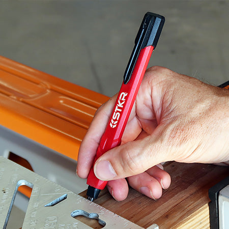 male hands wearing gloves marking an angle on a 2x4 using an STKR mechanical carpenter pencil